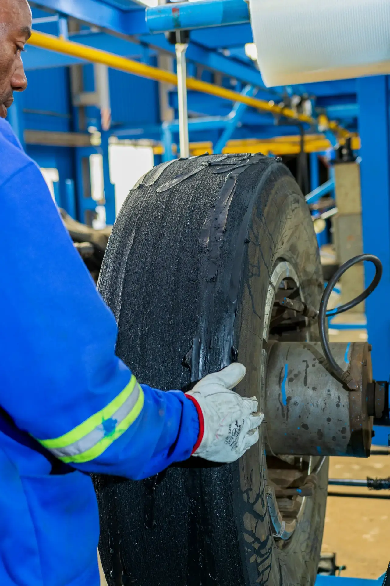 Close-up of a tyre casing being prepared on the retreading rig